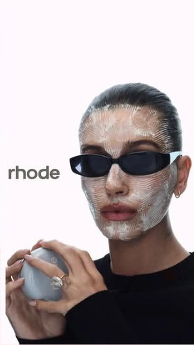 With button, sunglasses and cream mask holding the pebble jar